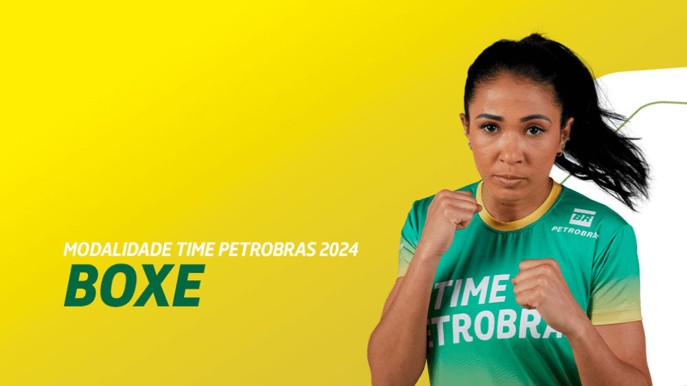 Uma atleta posa para a câmera com os dois punhos cerrados, em uma posição de boxe, usando uniforme do Time Petrobras.